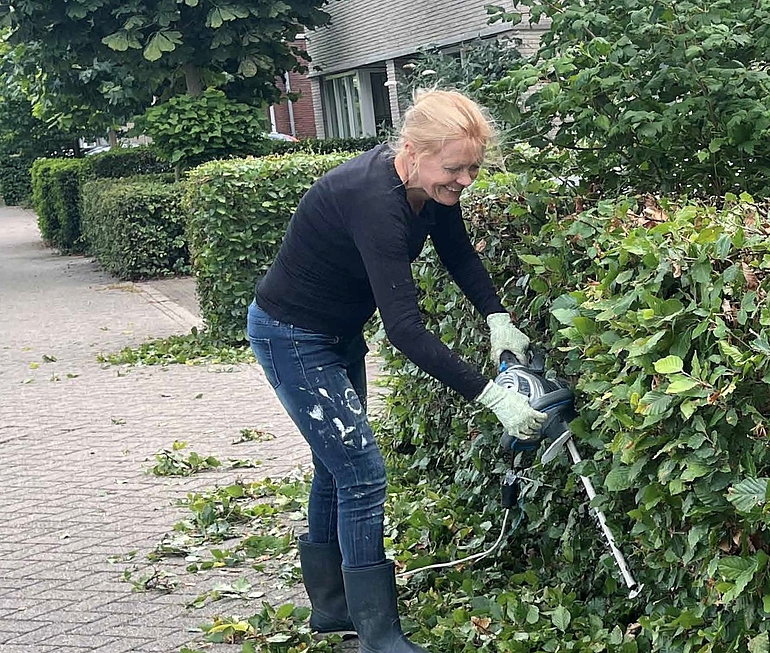 Vrouw die heg snoeit