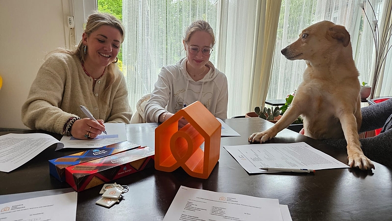 foto van 2 jongvolwassenen en een hond