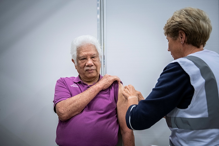 Foto man die gevaccineerd wordt door vrouw