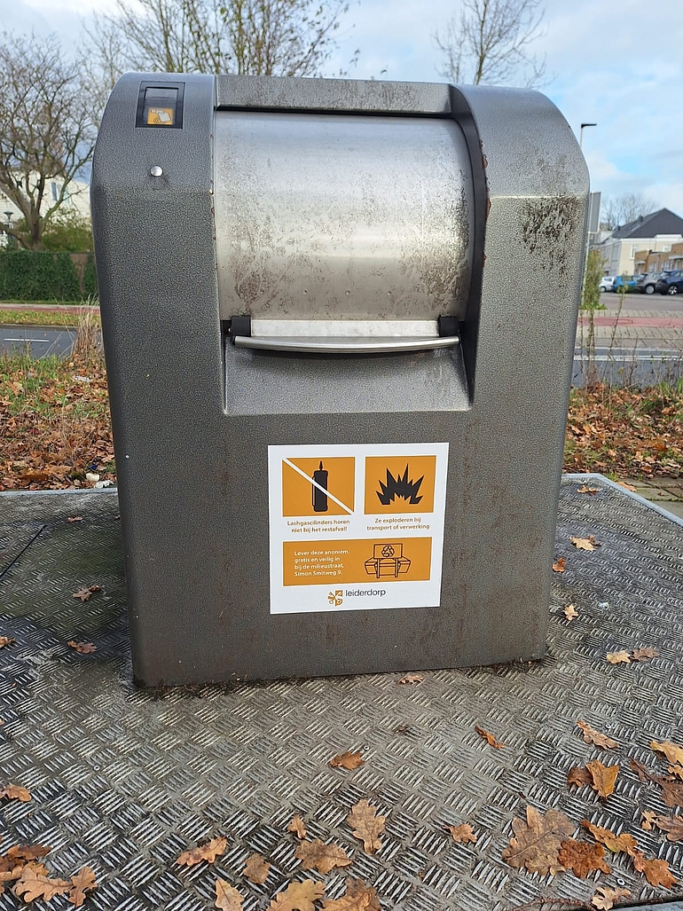 Container met sticker die informeert over het weggooien van lachgascilinders