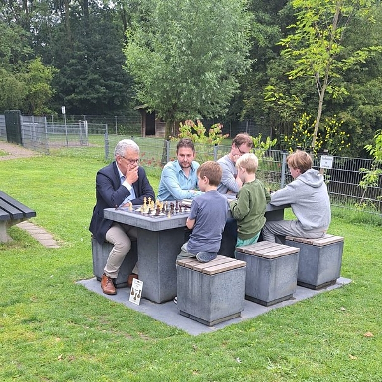 Foto van schakers aan nieuwe schaak- en damtafel in de Houtkamp