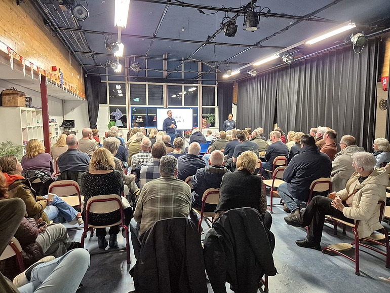 Bewoners luisteren naar de omgevingsmanager die uitlegt hoe de uitvoeringswerkzaamheden eruit zien.