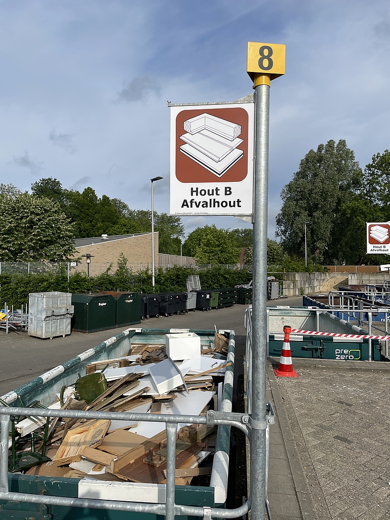 Foto van borden waarop te zien is welk afval in de container moet
