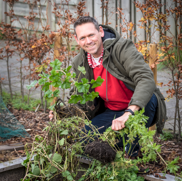 Foto van man die een plant poot