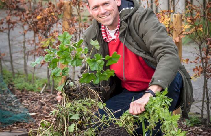 Foto van man die een plant poot